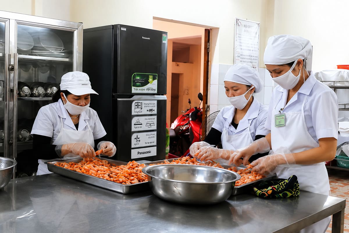 Mẫu đồng phục bếp màu trắng mang đến hình ảnh chỉn chu và chuyên nghiệp cho khu vực bếp trường học
